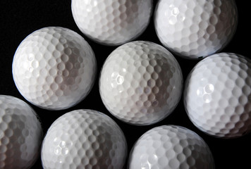 many golf balls on the black background
