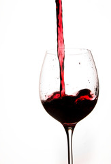 Pouring Red Wine in a Glass with White background