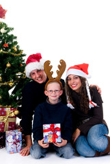 Christmas, happy couple with son, child next to Xmas tree