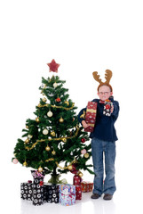 Christmas, happy young child next to Xmas tree wth presents
