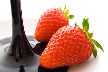 two strawberries and glass on white