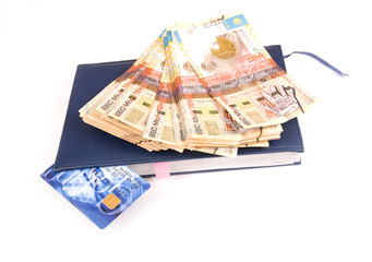 Stack of money or one credit card and notebook