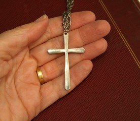 Christian cross in palm of hand, with bible.