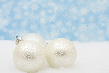 Silver glass Christmas balls on snowflake background