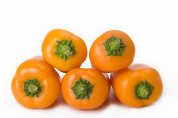 five orange bell peppers on white background
