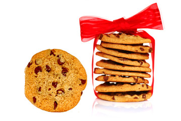 One chocolate chip cookie next to a stack of cookies