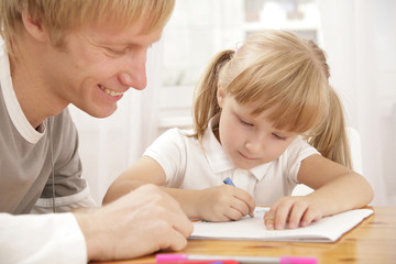 Portrait of little girl painting something and her father