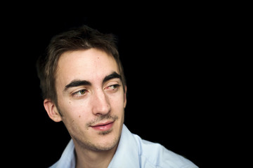 Fototapeta premium jeune homme séduisant regard de côté et sourire séducteur