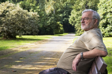 Obraz premium Senior man relax on a bench in park.