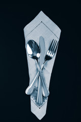 Fork, spoon and knife on a serviette
