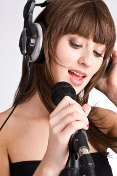 Woman in headphones Singing in to Microphone