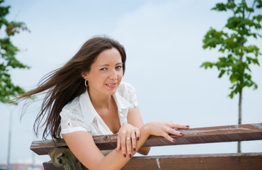 Portrait of a young cute woman sitting outdoors