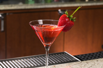 Strawberry on a Martini glass at a bar.