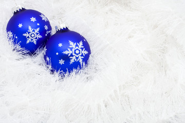 Blue glass ball on white shiny garland making a background