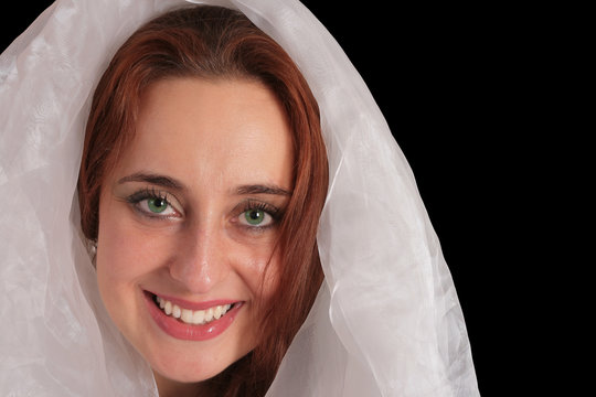 Ethereal green eyed young woman in white veil