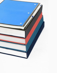 stack of books with note pad and pen sitting on top