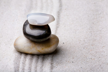 Fototapeta na wymiar tower of rocks in a sand zen rock garden