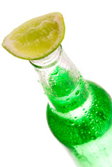 Bottle with lime slice on white background