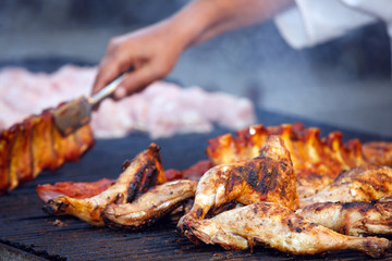 barbecue of grilled chicken legs with chef's hands