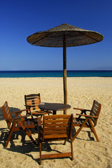 Chairs, table and grass-umbrella . Greece