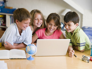 Fototapeta premium Group Of Young Children Doing Their Homework On A Laptop