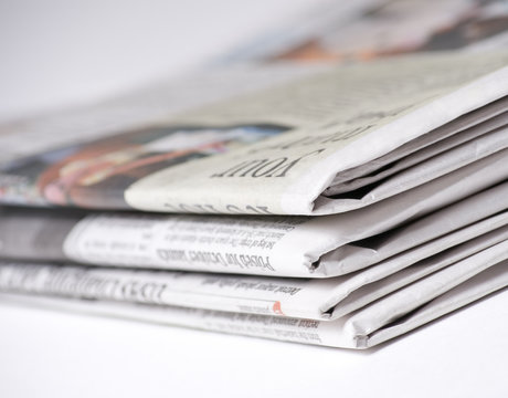 Newspapers on light background shot