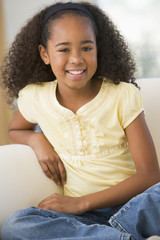 Fototapeta premium Young Girl Sitting On A Sofa At Home
