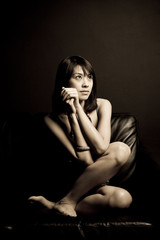 Obraz na płótnie Canvas A portrait of a beautiful asian woman sitting on a couch