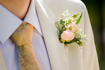 buttonhole with tea-rose detail of groom's dress
