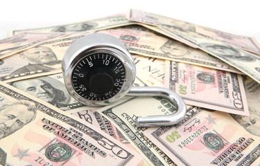 Unlocked combination lock shot over US Dollars banknotes