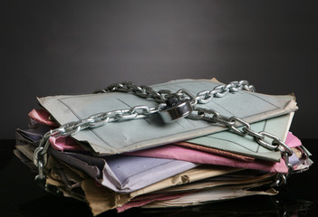 Stack of folders with chain and a padlock