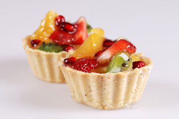 two ornate tarts with strawberry, kiwi, pomegranate and jelly