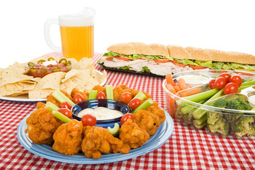 Table set with a variety of party foods and a pitcher of beer.