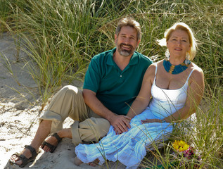 Couple holding hands sitting on beach