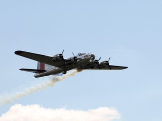 World War II era Flying Fortress bomber with smoke trail © icholakov