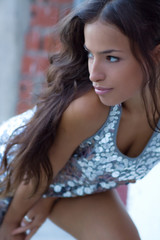 Naklejka premium young woman posing in shiny dress outside in dusk