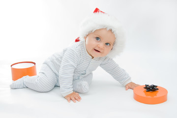 little, cute baby boy wearing Christmas hat, on white