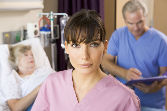 Nurse Standing In Hospital Room,Doctor Making Notes About Patien