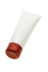Blank cosmetic tube in creamy white color and red cap