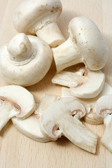 Sliced champignon mushrom on wooden chopping board