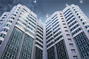 Fototapeta premium Modern glass business center with dramatic sky