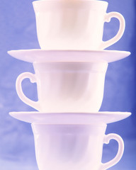 Pure white cups on  blue background, close up