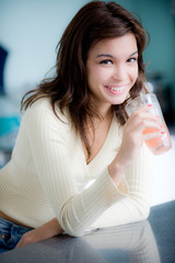 A young woman having juice in the kitchen