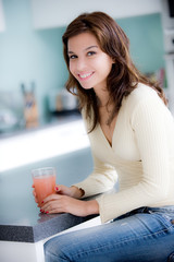 A young woman having juice in the kitchen