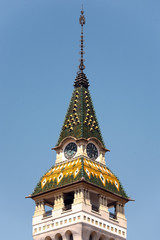 colorful tower with tiled roof in romania under blue sky