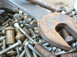 Assortment of rusty metal fasteners and wrench