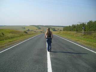 Fototapeta premium girl going far on road on background blue sky....