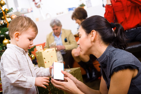 Little boy ( 3 years ) and mother giving Christmas present