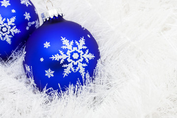 Blue glass ball on white shiny garland making a background