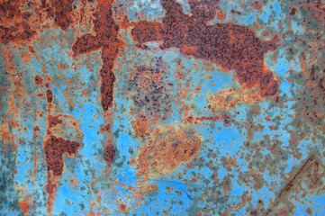 Metal texture background with peeled blue paint and rust
